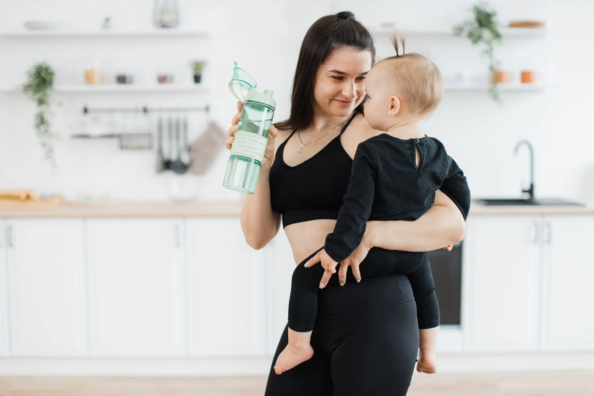 Post-Mommy Makeover Bliss: Reclaim Your Confidence at Victoria Heavenly Spa mom with sports bottle smiling at kid in arms at h 2023 11 27 05 35 34 utc 1920w